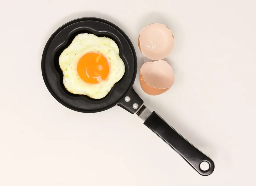 Jajko sadzone z żółtkiem na małej patelni, w żółtku jest cholesterol pokarmowy