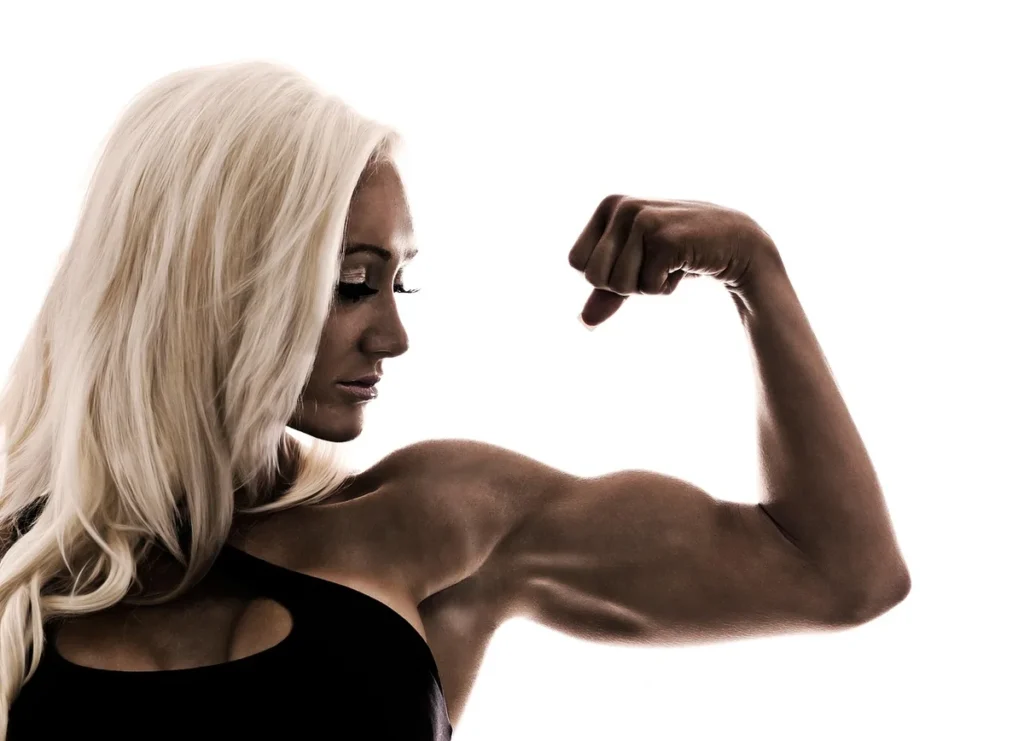 Kobieta napina biceps: masa mięśniowa i jej utrata po odstawieniu treningu